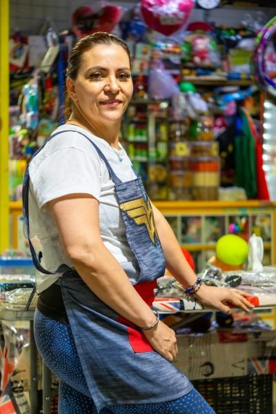 Portrait of a Latina woman running a shop in Mexico City. Vibrant and busy market scene.
